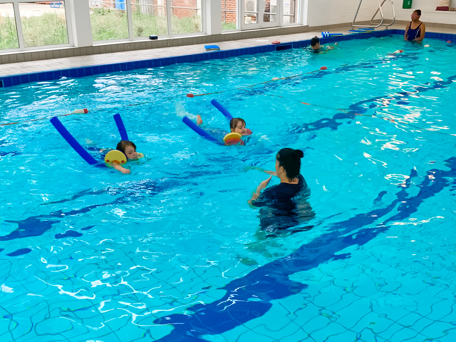 2 children swimming with foam floaters in a 2 to 1 lesson_SwimPlus in Enfield and Barnet